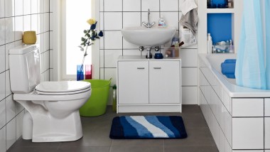 Cluttered bathroom seen before the renovation, with floor-standing WC and exposed cistern