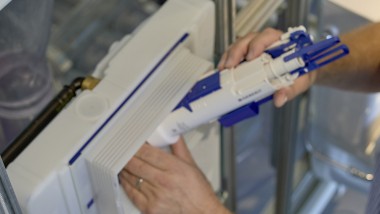 A man installs a Geberit flush valve in a concealed cistern (© Ben Huggler)